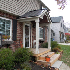 front of a brick and siding home with three steps leading up to porch