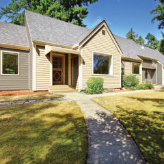 front of upgraded ranch style home with new beige siding green lawn in front